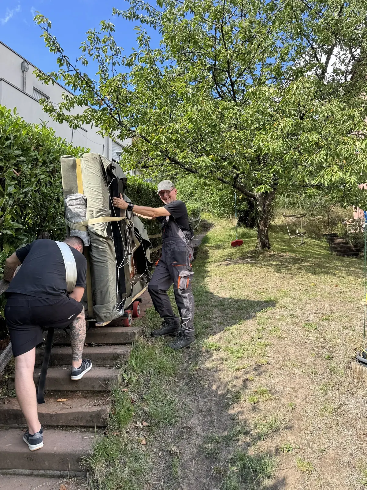 Klaviertransport Spandau: Klavier auf dem Weg durch den Garten